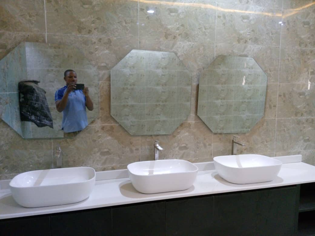 Three vessel basins on a stone counter in a commercial washroom