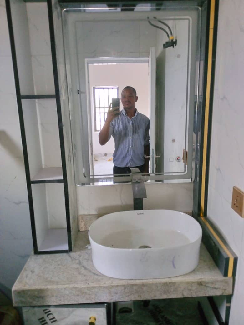 Marble bathroom vanity with vessel basin and black framed mirror